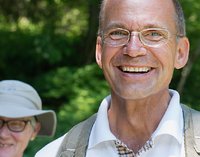 [Bitte in "Französich" uebersetzen:] Ein lächelnder Mann auf grünem Hintergrund