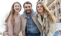 Deux femmes et un homme se tenant les uns à côtés des autres