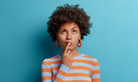 Une femme avec un doigt posé sur sa bouche