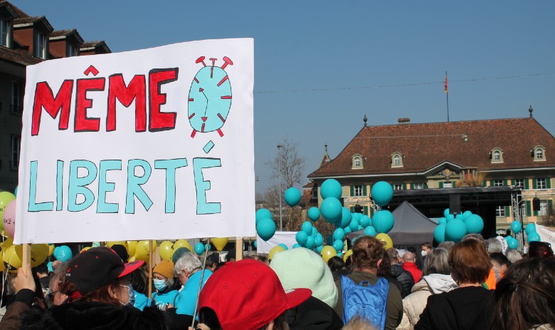 Politik Eine Ansammlung von vielen Menschen. Im Vordergrund wird ein Schild hochgehalten auf dem Steht "Même Liberté"